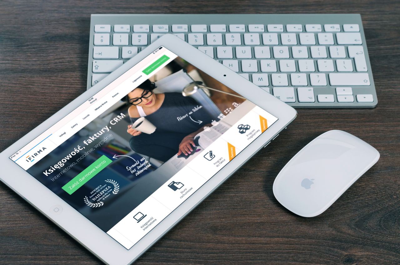A tablet showing a financial website, paired with a white keyboard and mouse. Well suited for tech-themed stock imagery.