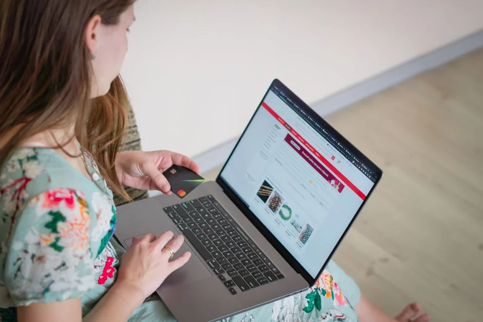 An organized desk scene with a laptop displaying a stock photo website and a smartphone.